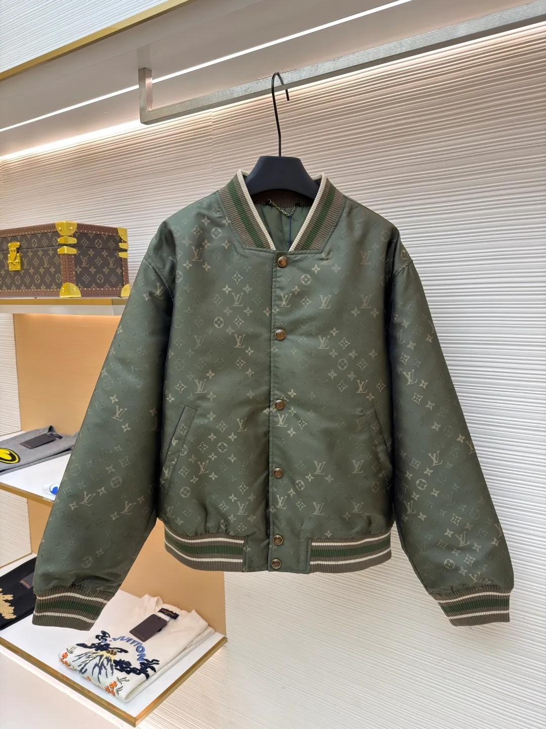 LOUIS VUITTON striped trim jacquard long-sleeved bomber jacket ●Original version: purchased and developed by 29237 ●Item number: 1682087-C05 ●Fabric: nylon fabric ●Technology: jacquard production ●Color: green ●Version: fitted version ●Weight: about 800 grams ●Size: S-M-L-XL ●Description: This Louis Vuitton baseball jacket is made of high-density jacquard satin fabric. The base is a polyester fiber blended material with a military green matte texture. The classic Monogram presbyopia pattern is woven into the fabric in the form of dark patterns of the same color through a special weaving process. The pattern texture is three-dimensional and presents a delicate illusion luster with the angle of light. High-precision jacquard weaving technology is used in the process to ensure the integrity and delicacy of the pattern. The body adopts a single-row metal snap closure design. The metal buckles are matte and distressed to echo the color of the body. The ribbed collar, cuffs and hem are made of two-color knitting technology. The elastic ribs have both stiffness and comfort, and are pre-shrunk to prevent deformation. The overall cut is a loose oversize version, and the splicing uses a combination of flat seams and hemming techniques. The interior is supplemented by smooth overlock sewing. Every stitch is even and fine, which fully reflects the brand's exquisite garment production technology and detail control. The overall wiring is straight and delicate, the fabric is comfortable and soft, and the color is consistent without color difference. It can be matched with the same style to create a fashionable look and control various occasions. Customized accessories, complete with three standards, same style for men and women!